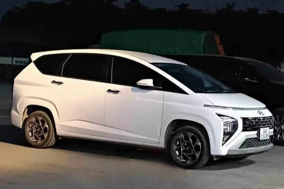 A modern white MPV prepared for a night transfer under streetlights in Vietnam.
