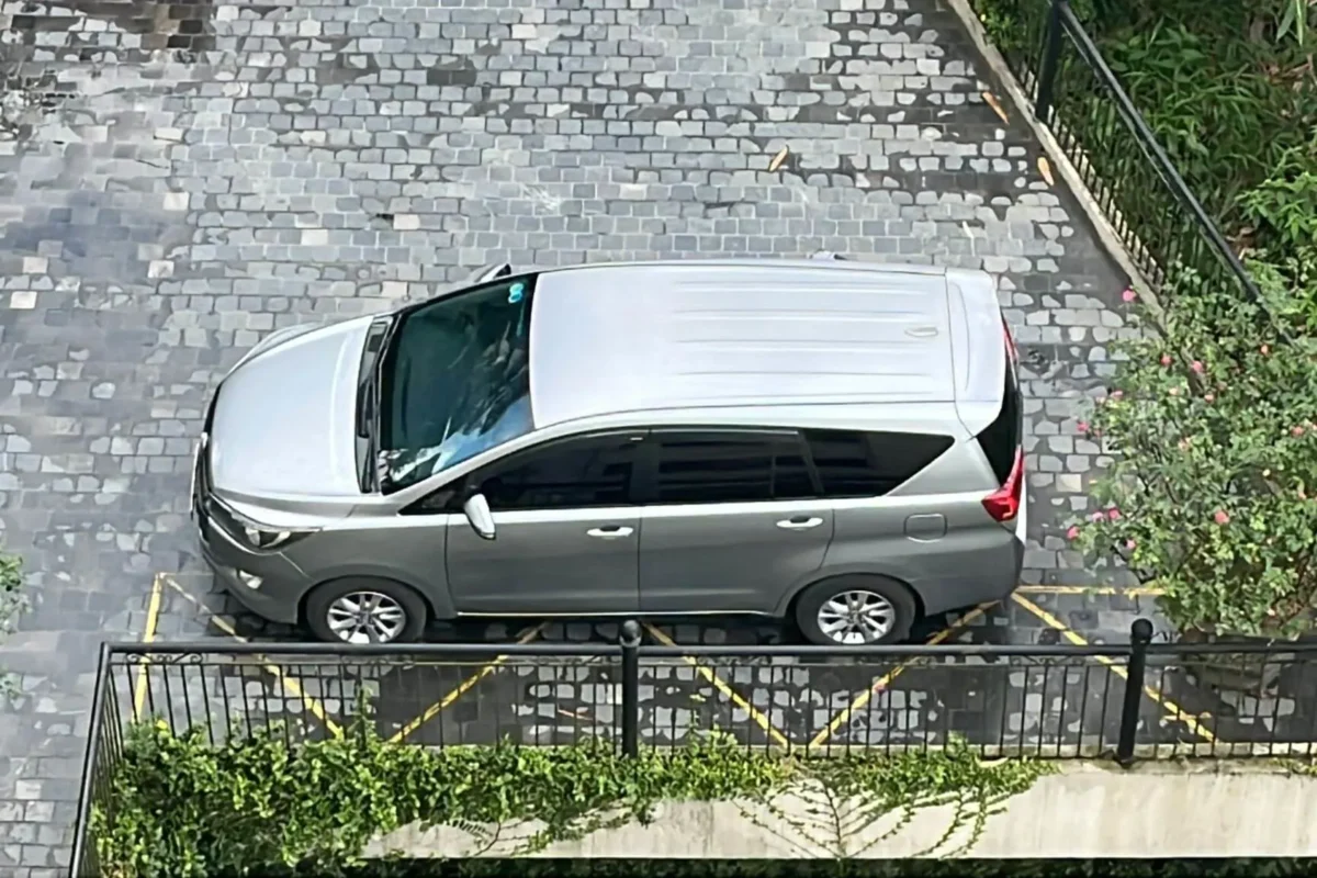 Aerial view of a private 7-seater SUV arriving at a cobblestone hotel entrance in Sapa.