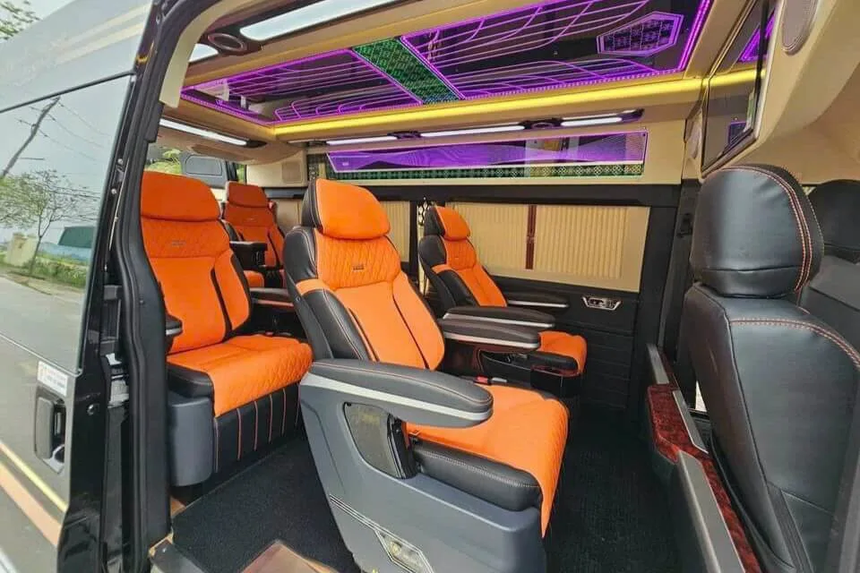 High-tech 11-seater van interior featuring orange leather quilted seats and purple LED ceiling.