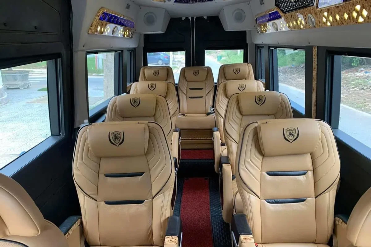 Spacious interior of a 9-seater van showing wide aisles and clean tan leather upholstery.