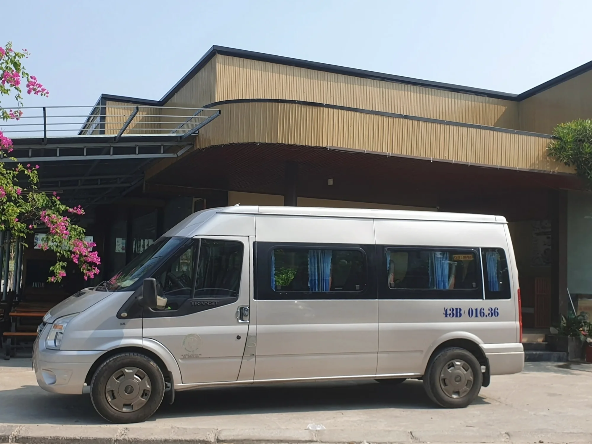 Silver 16-seat private van with privacy curtains on the windows