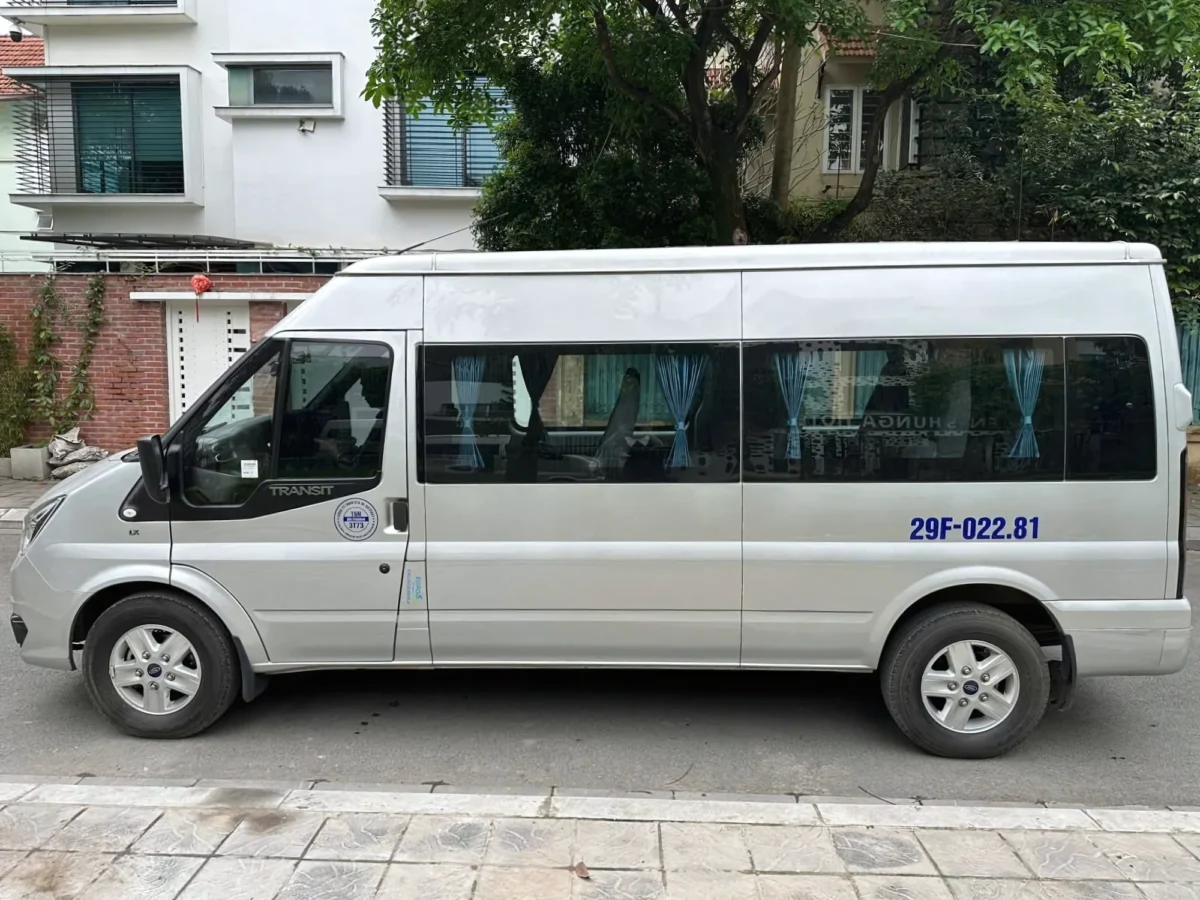16-seat private van with doors open at a hotel entrance in Ha Long Bay