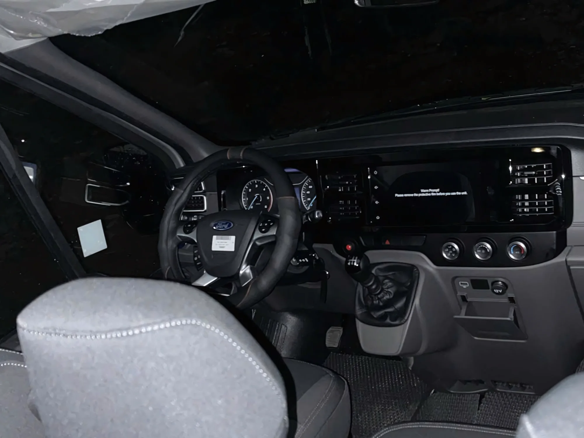 Night-lit cockpit of a 16-seat private van ready for early departure