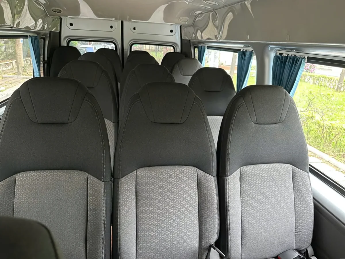 Full passenger cabin with privacy curtains inside a 16-seat private van