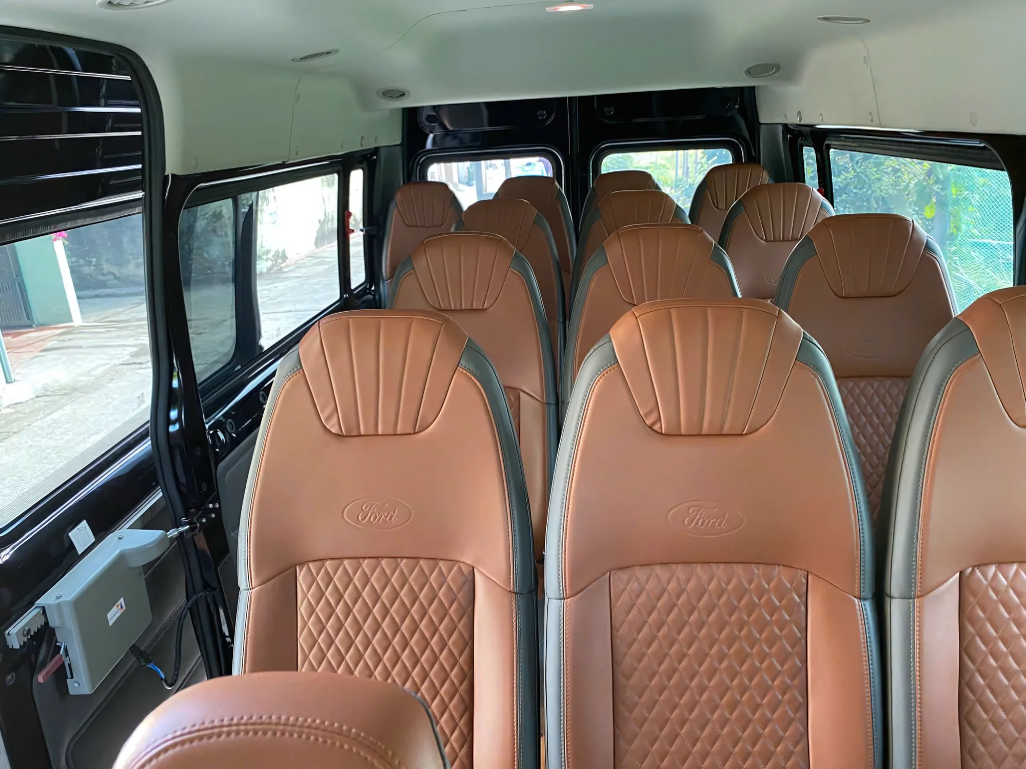 Brown quilted leather passenger seats in a 16-seat Private Vietnam van