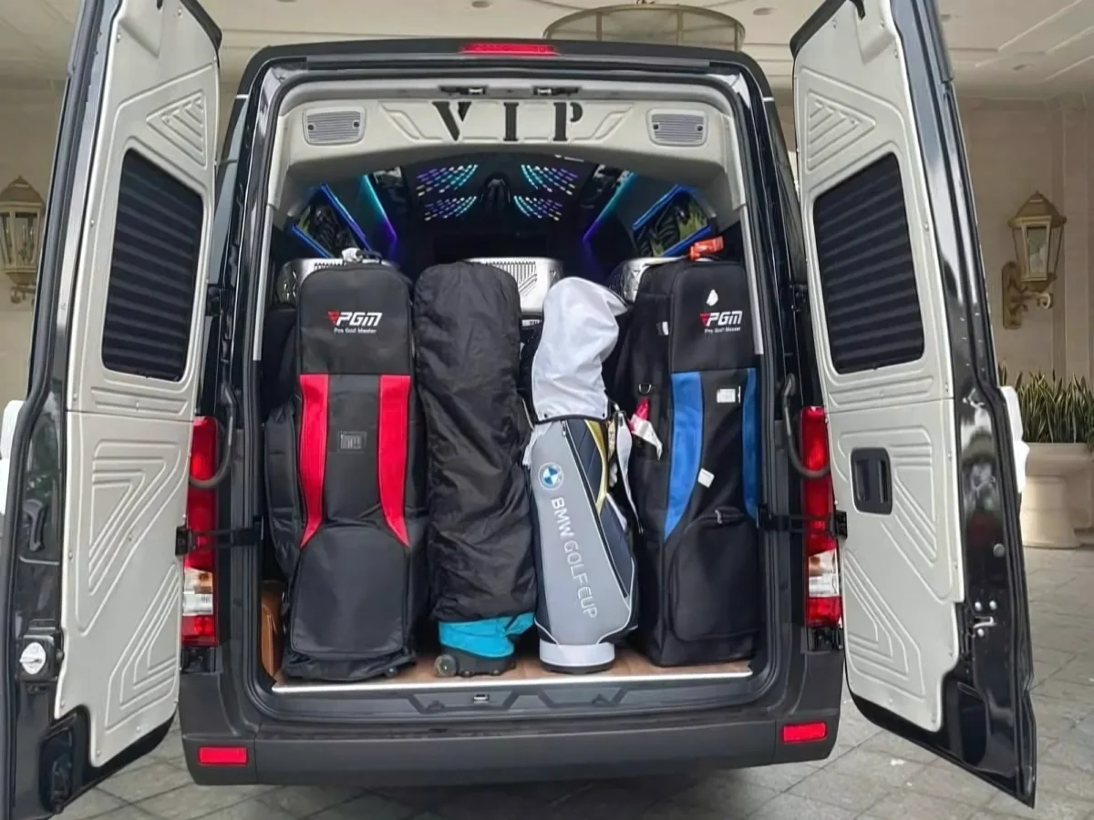 Open rear cargo doors of a 16-seat private van — luggage for Hanoi to Ha Long Bay group
