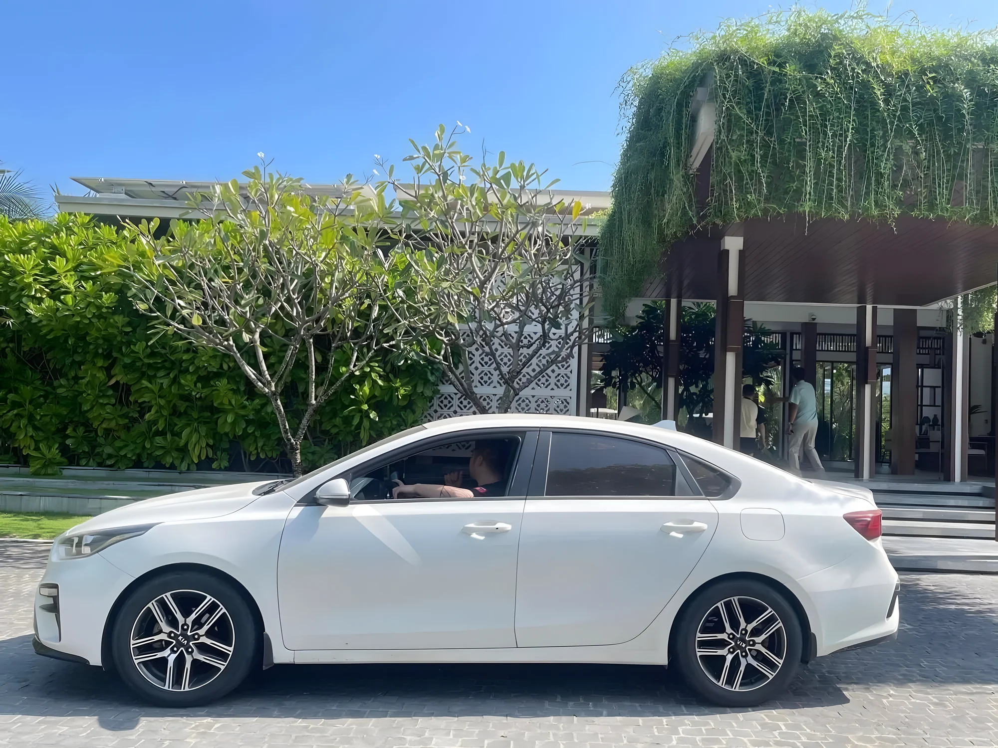 White 5-seat sedan at a hotel entrance for the Hanoi to Sapa transfer