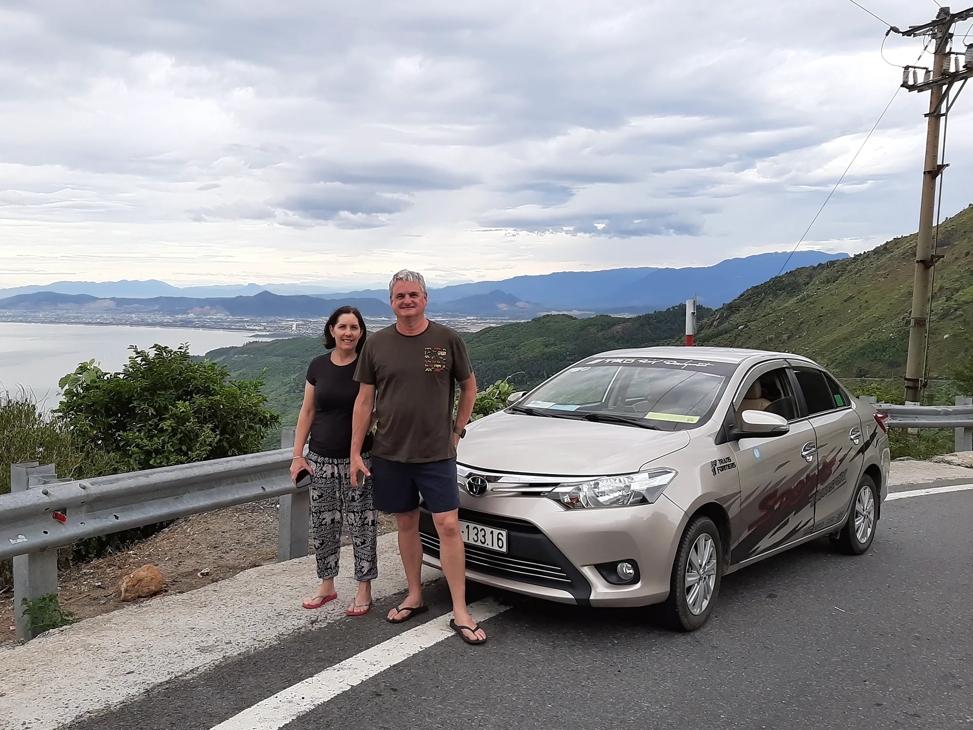 Couple with driver at a mountain viewpoint on the Sapa to Hanoi route