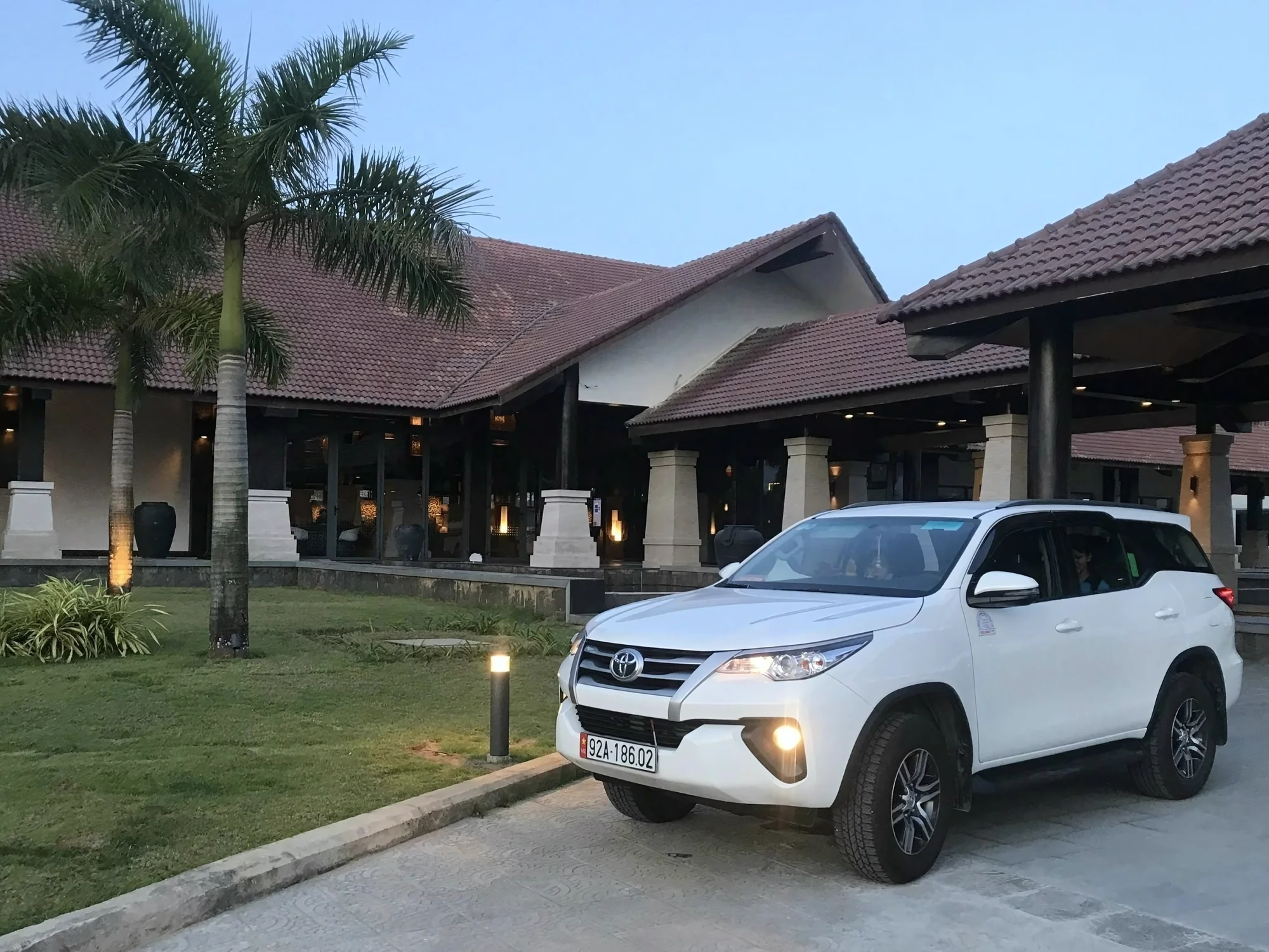 White 7-seat Private Vietnam SUV with doors open at a hotel pickup in Sapa