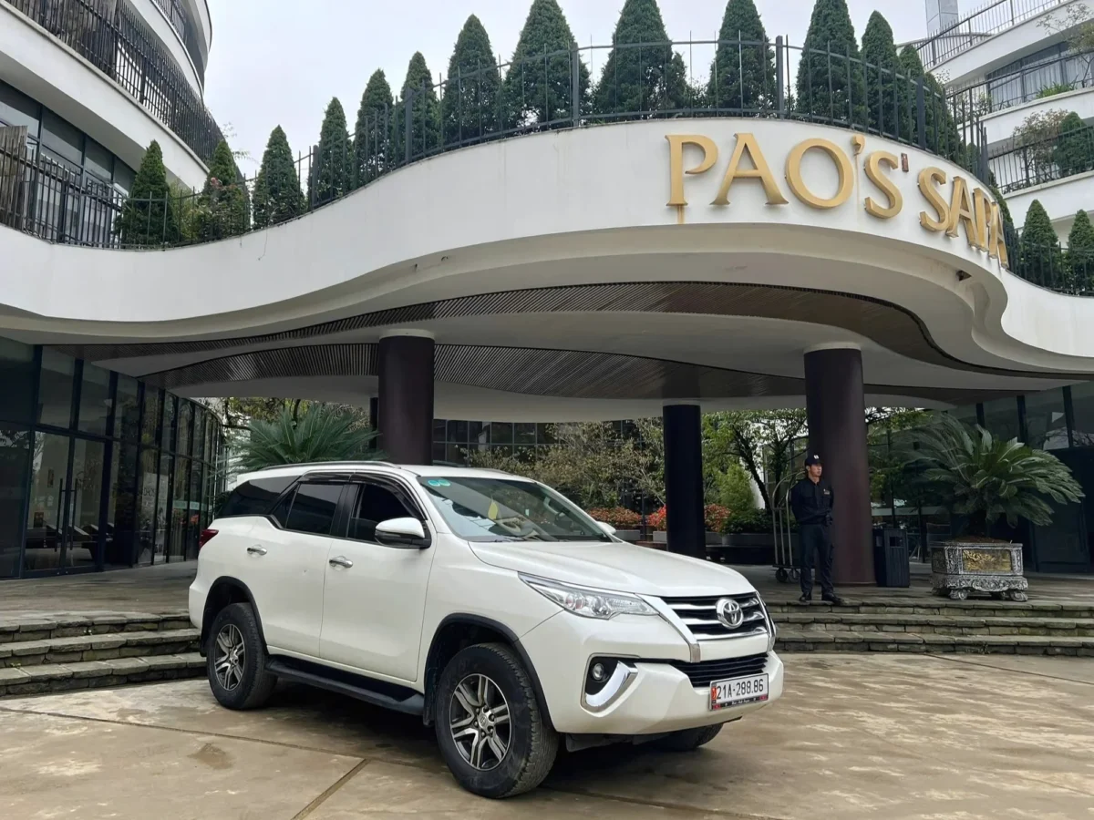 White 7-seat Private Vietnam SUV arriving at a hotel — Hanoi Ha Long Bay transfer