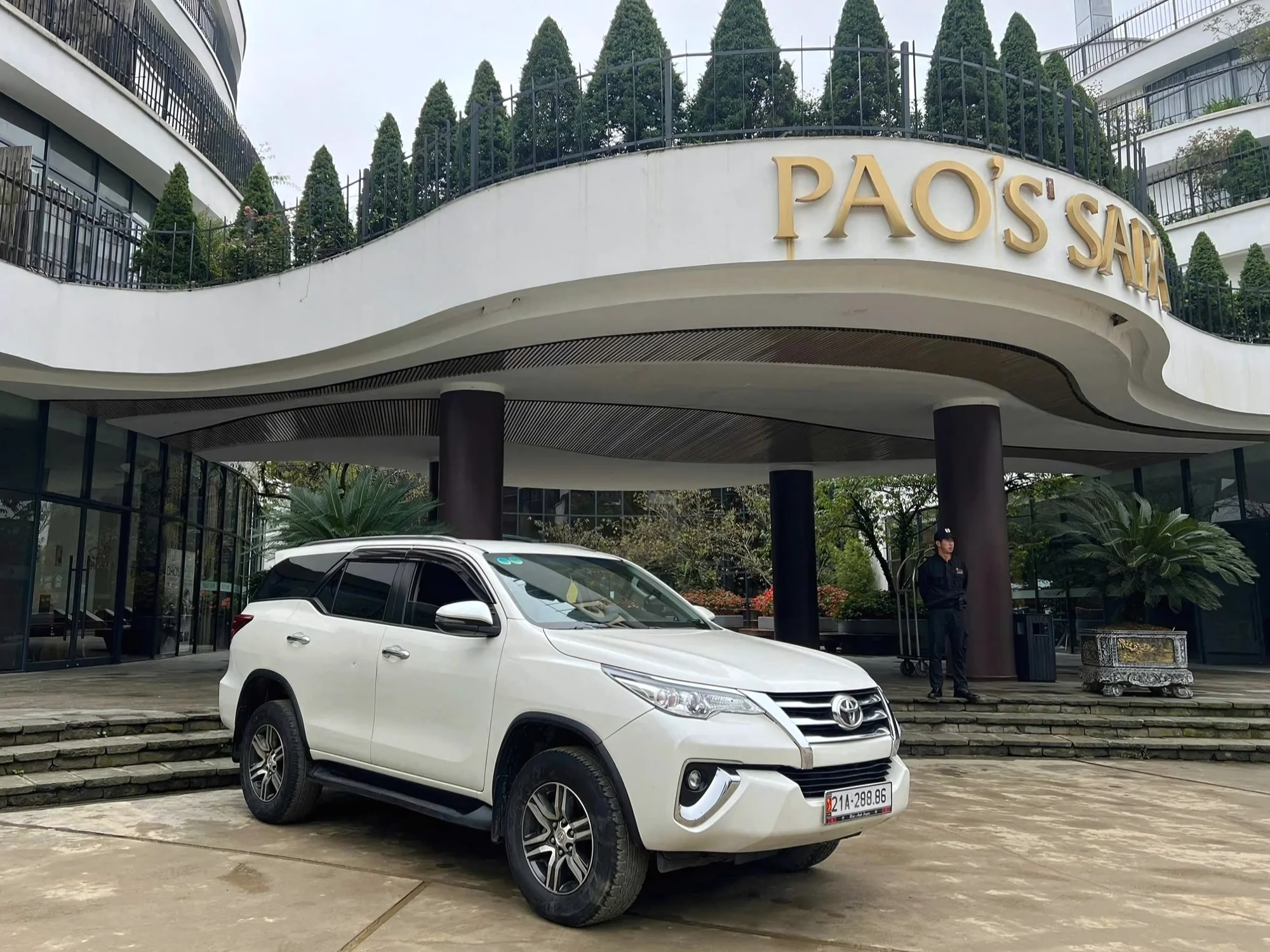 White 7-seat Private Vietnam SUV at a hotel after transfer from Hanoi