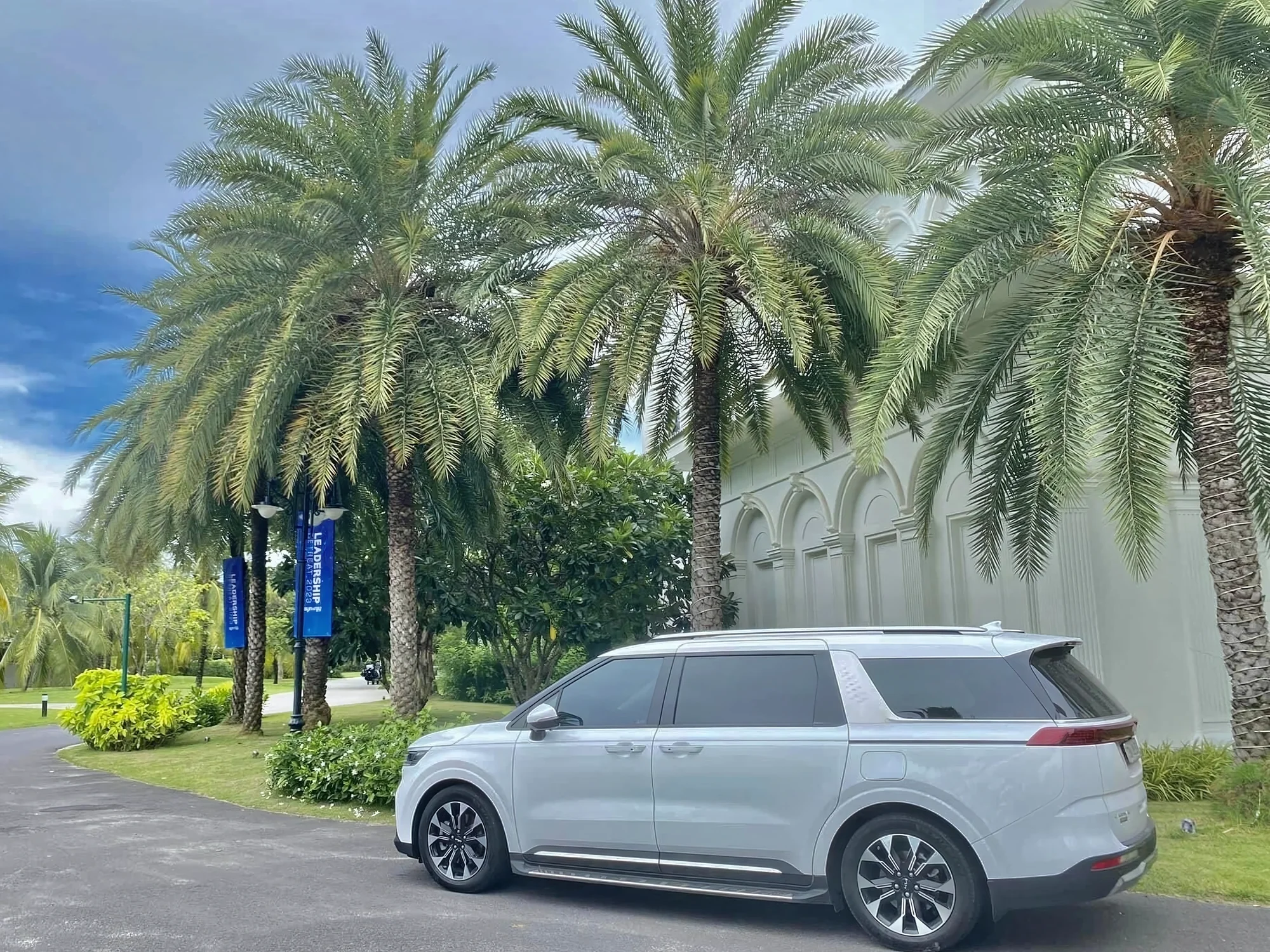 Silver 7-seat MPV on a Vietnamese road — lower entry height for families