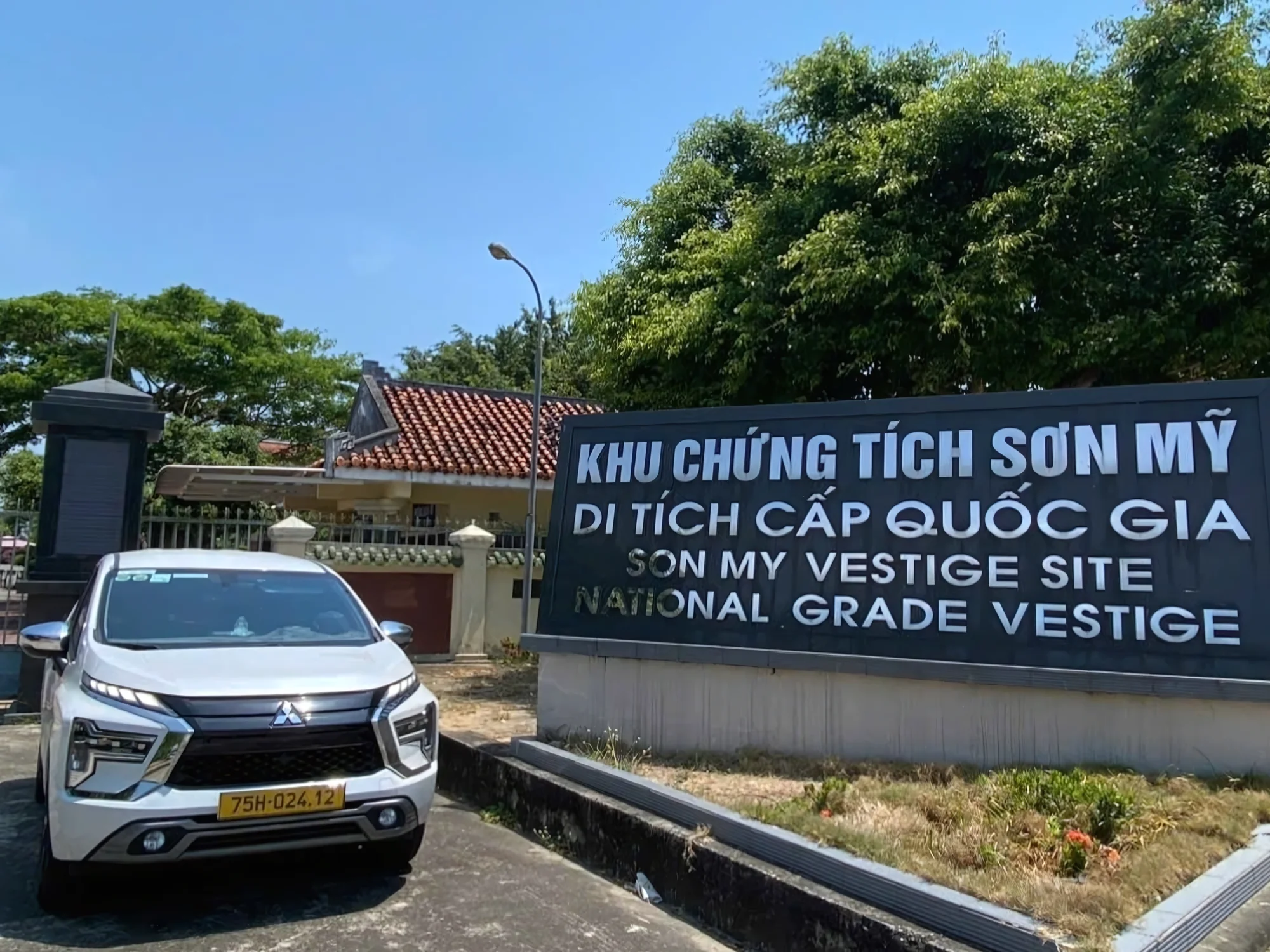 White 7-seat SUV parked at a Vietnamese cultural site during a private car stop