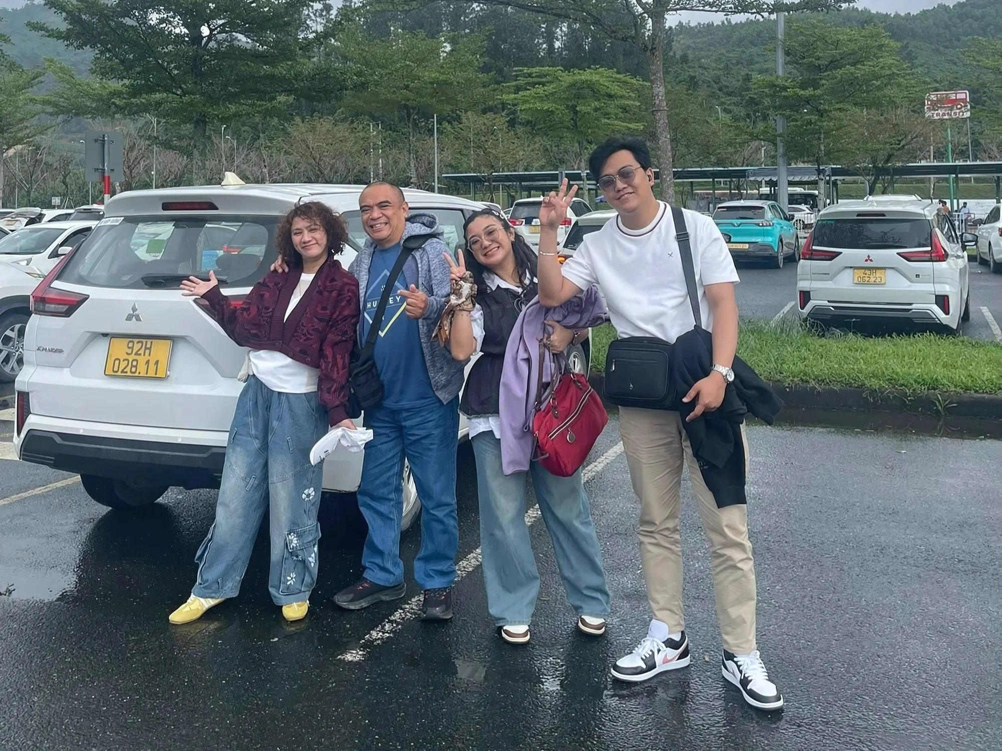 Four travellers with a white 7-seat Private Vietnam SUV — one fixed vehicle price