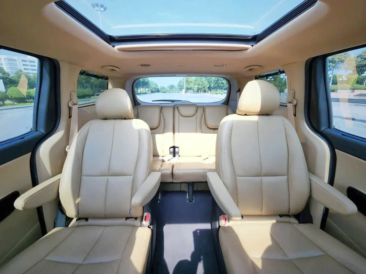 Cream leather captain seats and panoramic sunroof inside a 7-seat private car