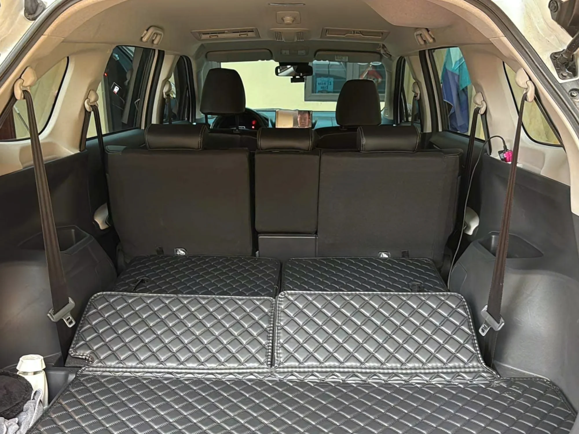 Full cargo area of a 7-seat SUV with seats flat — space for 4 large suitcases