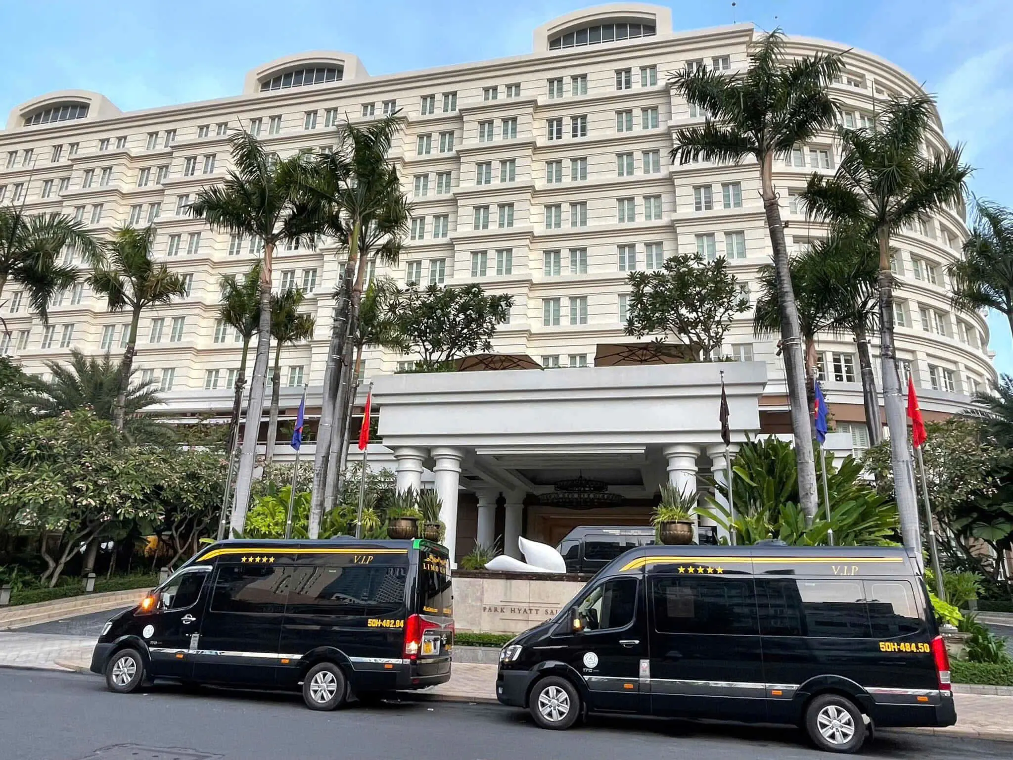 Two black VIP limousine vans at a luxury hotel for a group transfer
