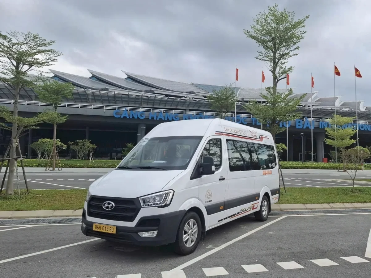 White VIP van at a Vietnamese airport arrivals area with luggage