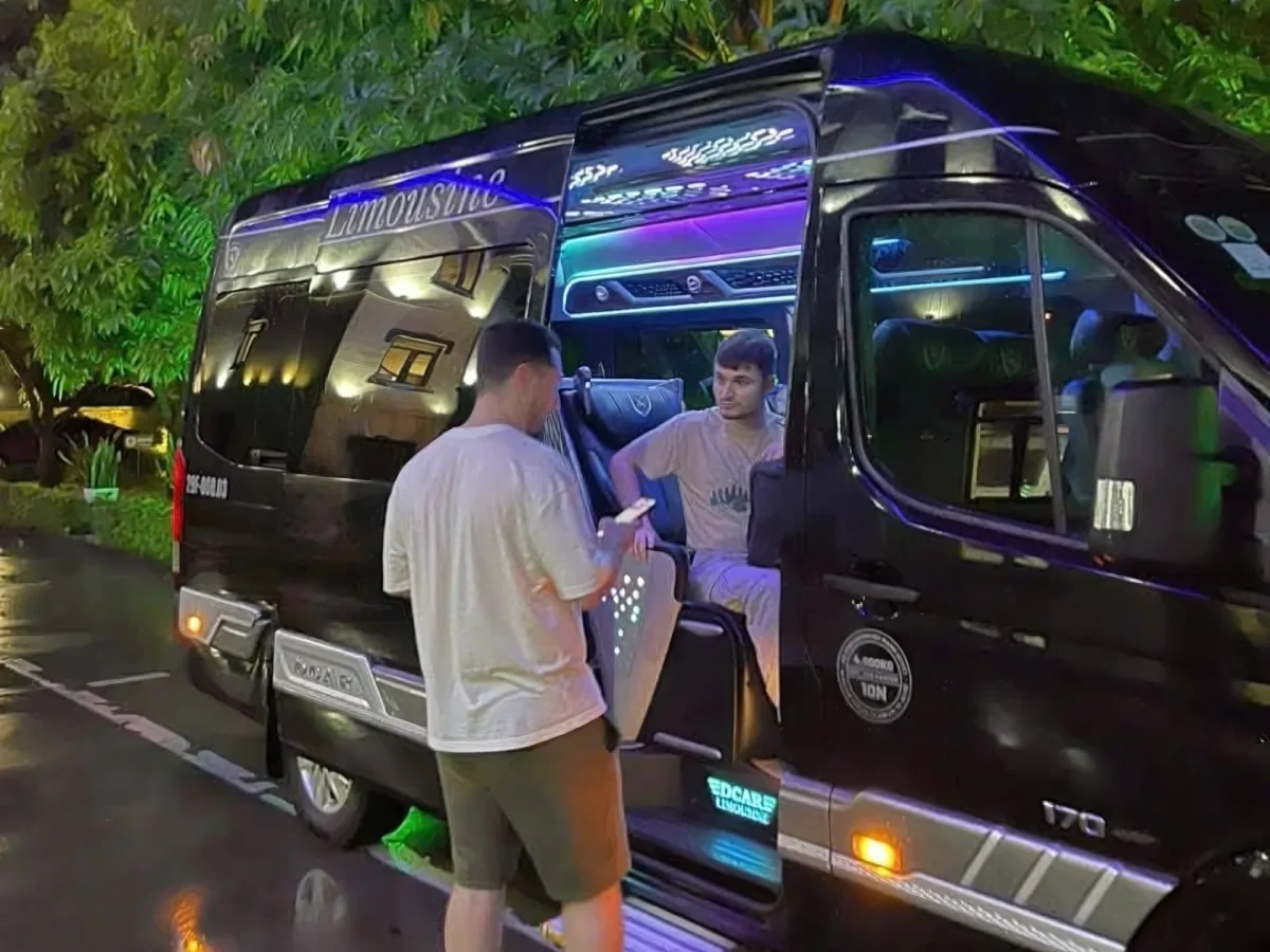 Young travellers boarding a VIP van at night — Hanoi to Ha Long Bay private car