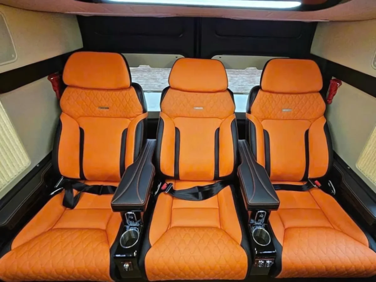 Last-row orange leather captain seats with full recline and fold-out armrests
