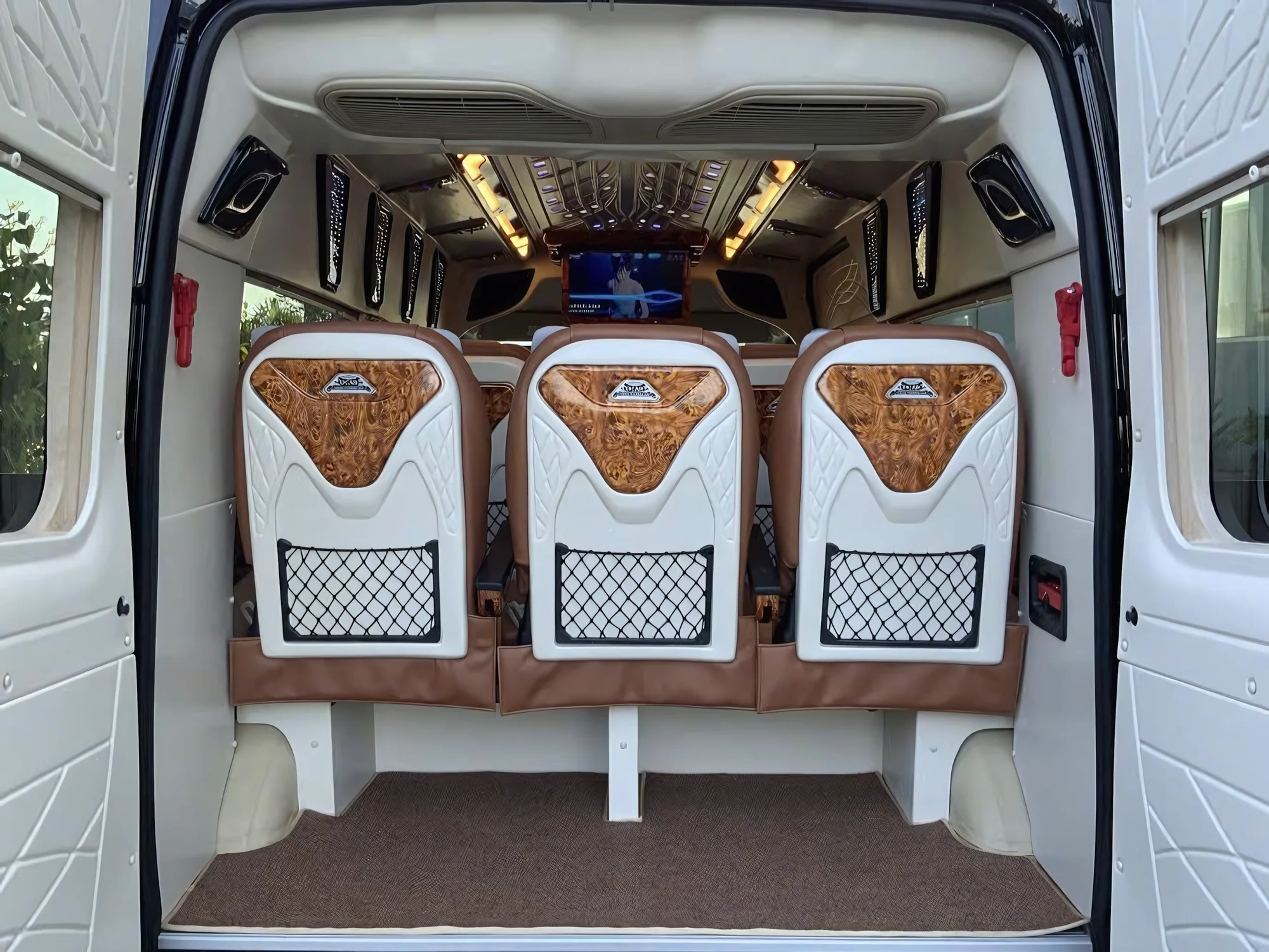 Rear interior of a VIP private van with mesh seat-back storage pockets
