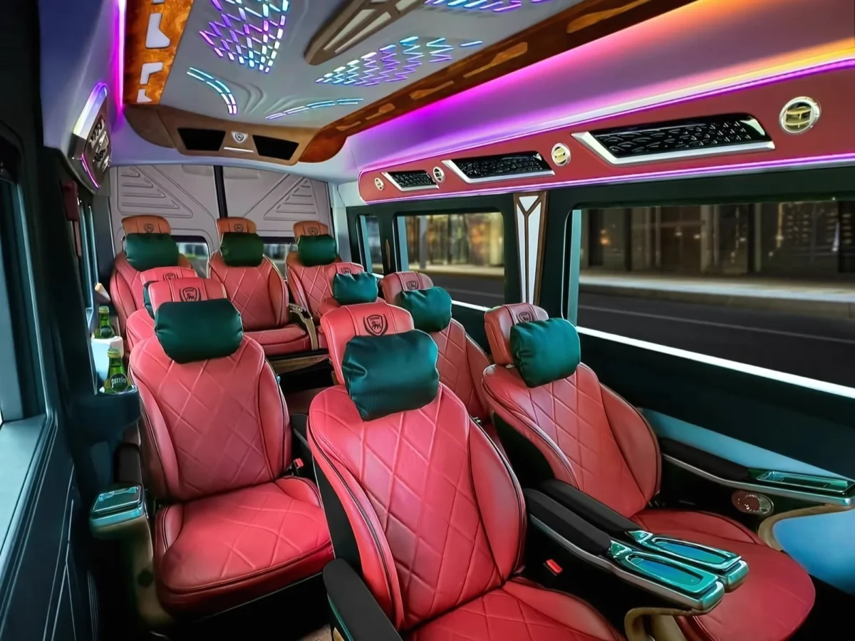 Pink quilted leather seats with teal headrests under purple lighting in a VIP van