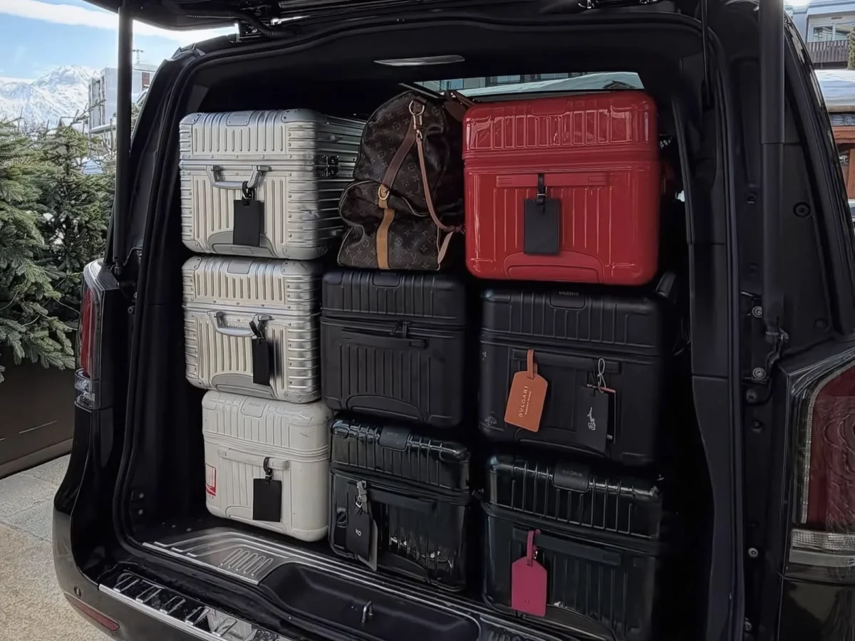 An open vehicle trunk packed neatly with multiple large hardshell suitcases and travel bags for a vietnam private transfer and airport car with driver vietnam service.